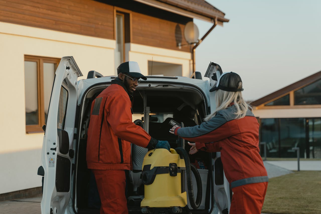 Crafting Captivating Headlines: Your awesome post title goes here Two cleaners in red uniforms load a vacuum into a white van outdoors.
